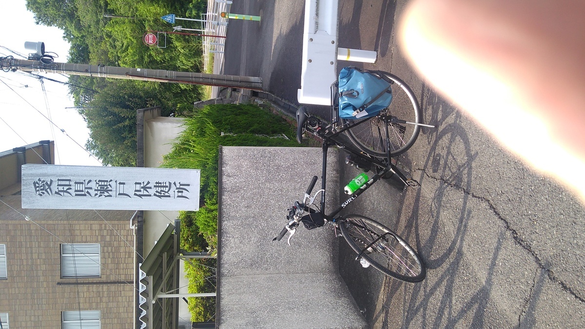 A bicycle parked in front of a sign reading (in English translation) “Aichi Prefecture Seto Health Services Office”