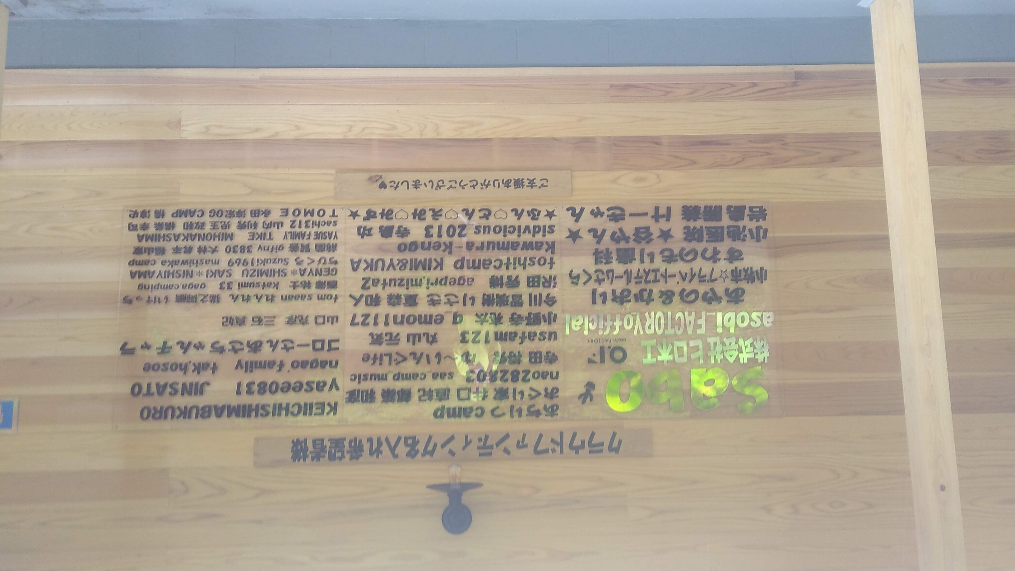 A wooden sign reading (in English translation) “Crowdfunding contributors inviting recognition,” followed by a list of over forty screen and personal names, and finally “Thank you for your support!”