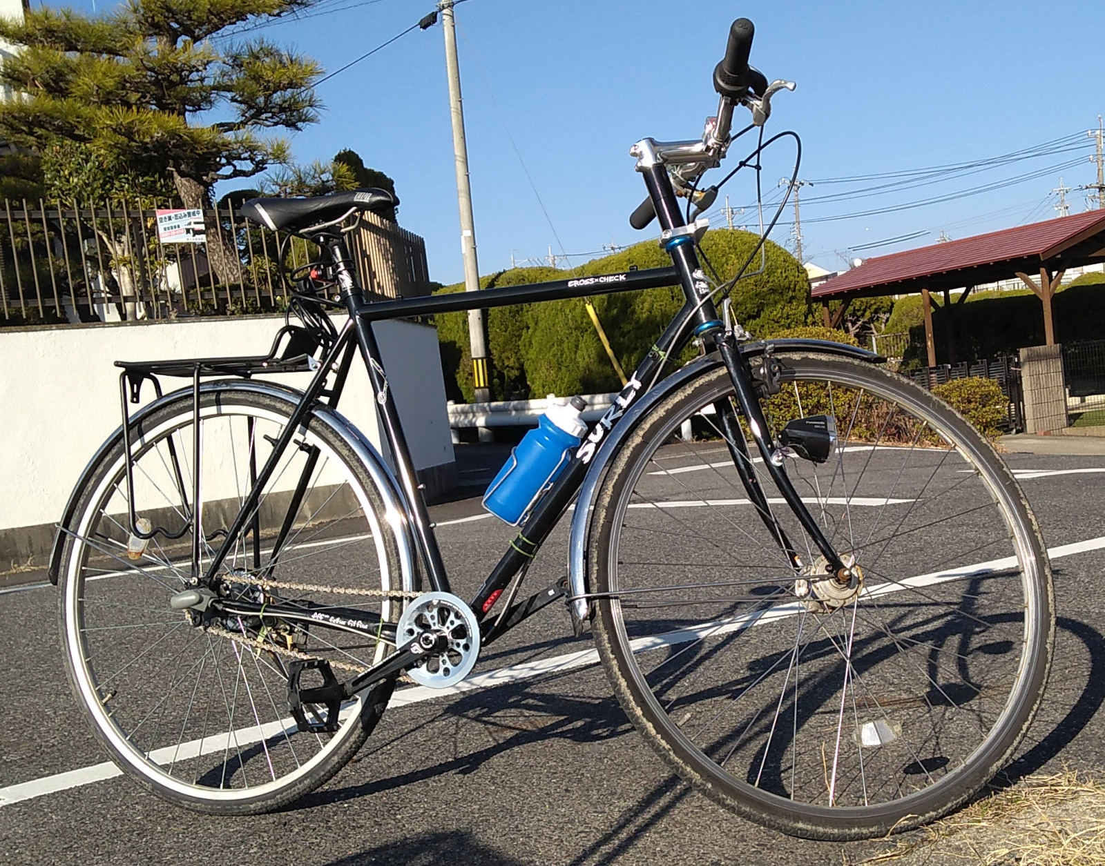 A black diamond-frame bicycle with 27" wheels, a rear rack, and a three-speed bub.